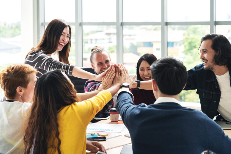 Office staff high fiving.