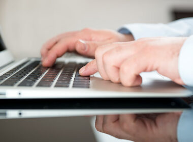 man typing on computer keyboard, two websites