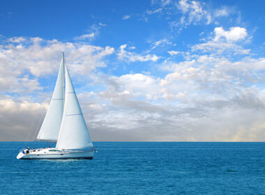 Modern sailboat coasting on calm blue water