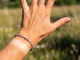 A woman's hand, tanned from the sun, with a tan line on her left wrist in place of a watch.