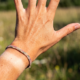 A woman's hand, tanned from the sun, with a tan line on her left wrist in place of a watch.